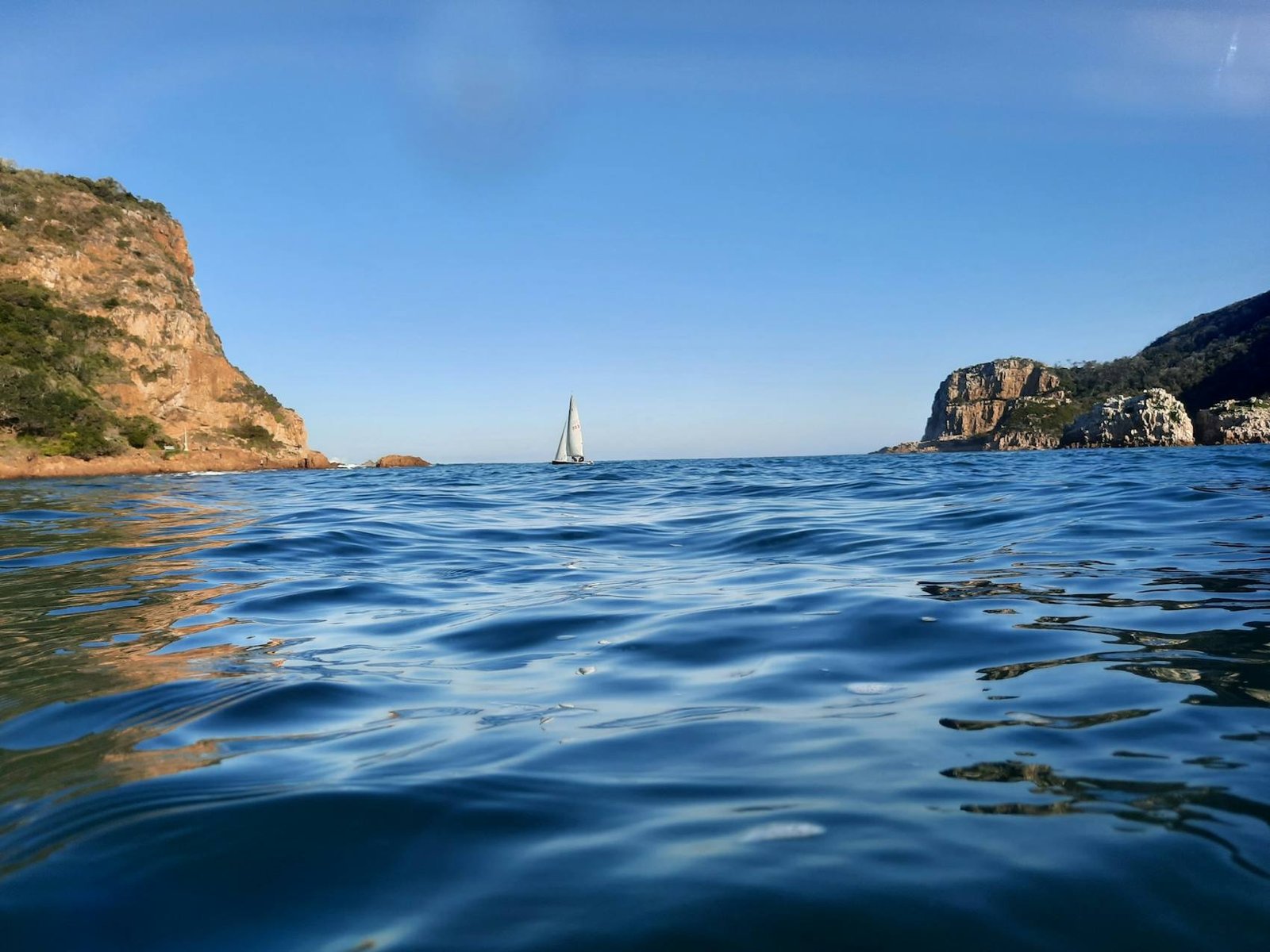 Sailing boat on the water below the Cape cliffs